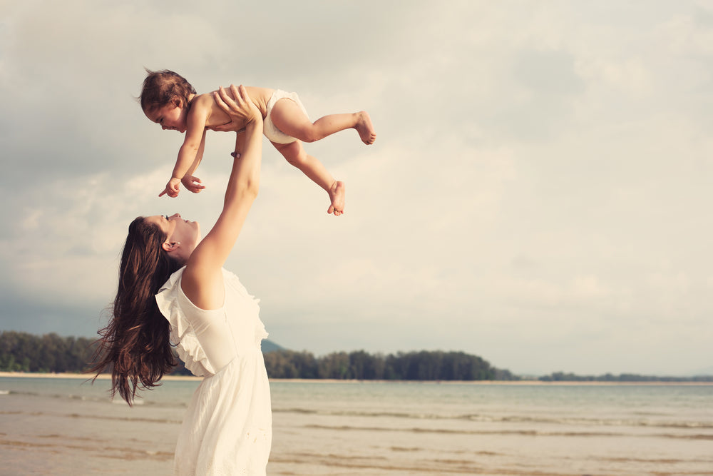 mom and baby playing at beach